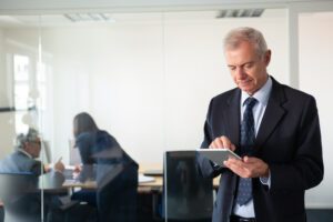 Focused mature businessman using tablet